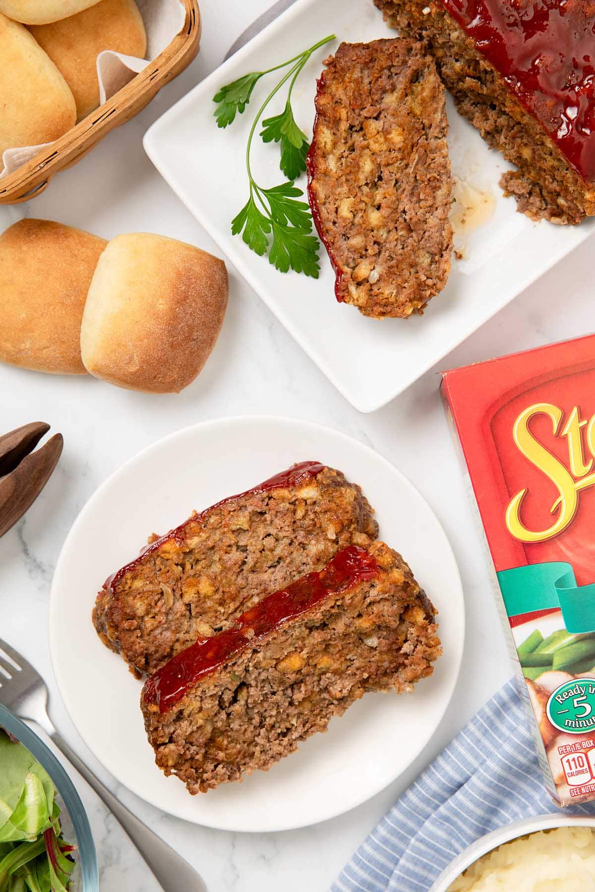 Two slices of Stove Top Stuffing Meatloaf with ketchup glaze on a plate.