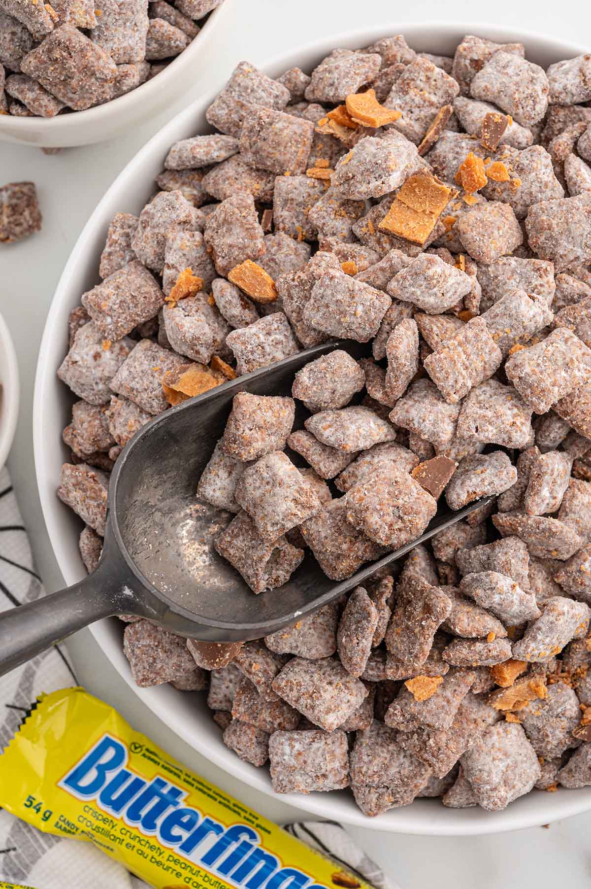 Butterfinger Puppy Chow with a scoop and Butterfinger bar nearby.