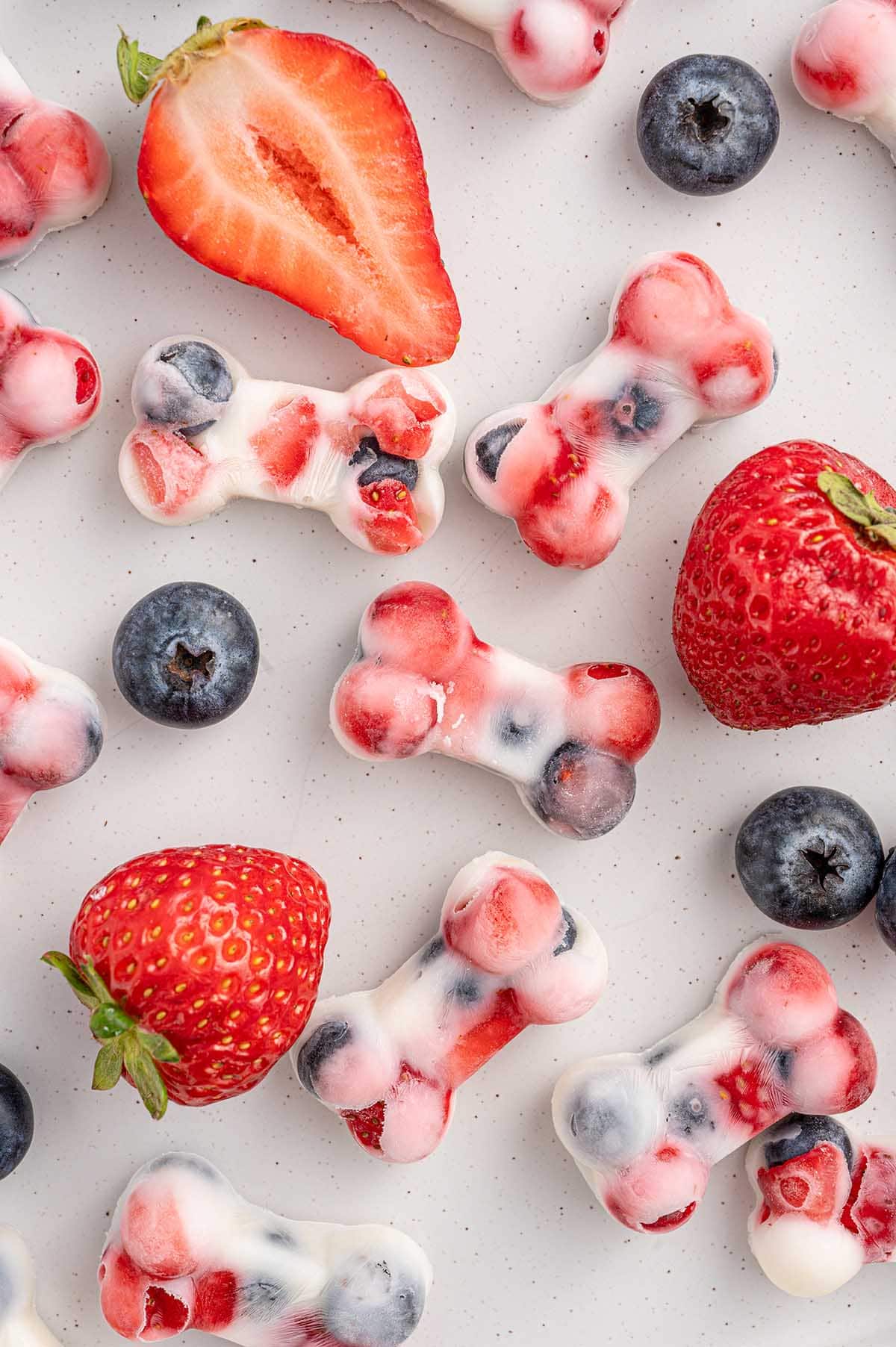 yogurt dog treats with a couple of strawberries on the table. 