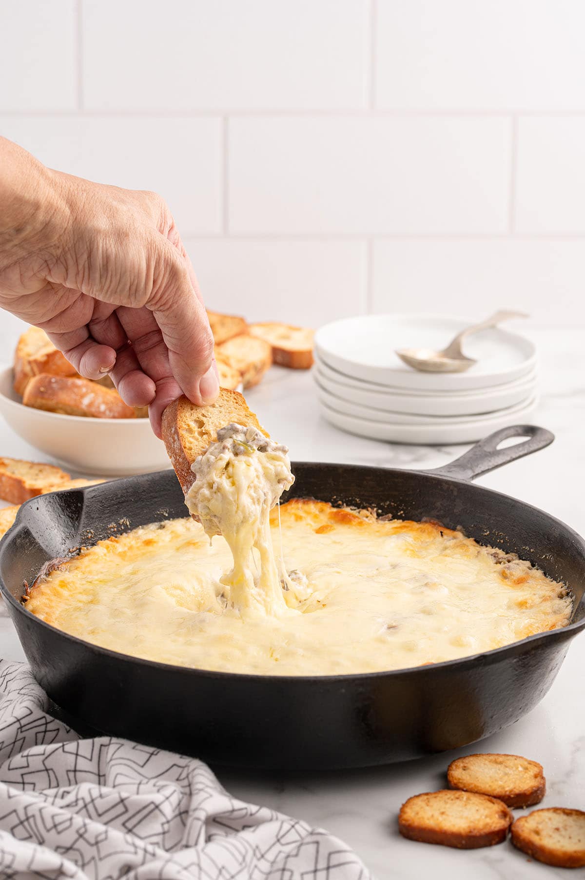 Philly cheesesteak dip on a toasted baguette with melty cheese.