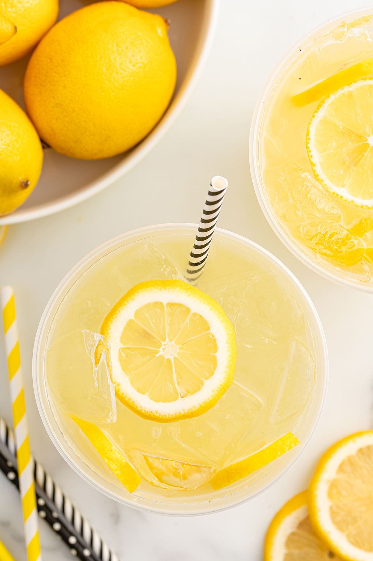 State Fair Lemonade with lemon slices, ice, and a striped straw.