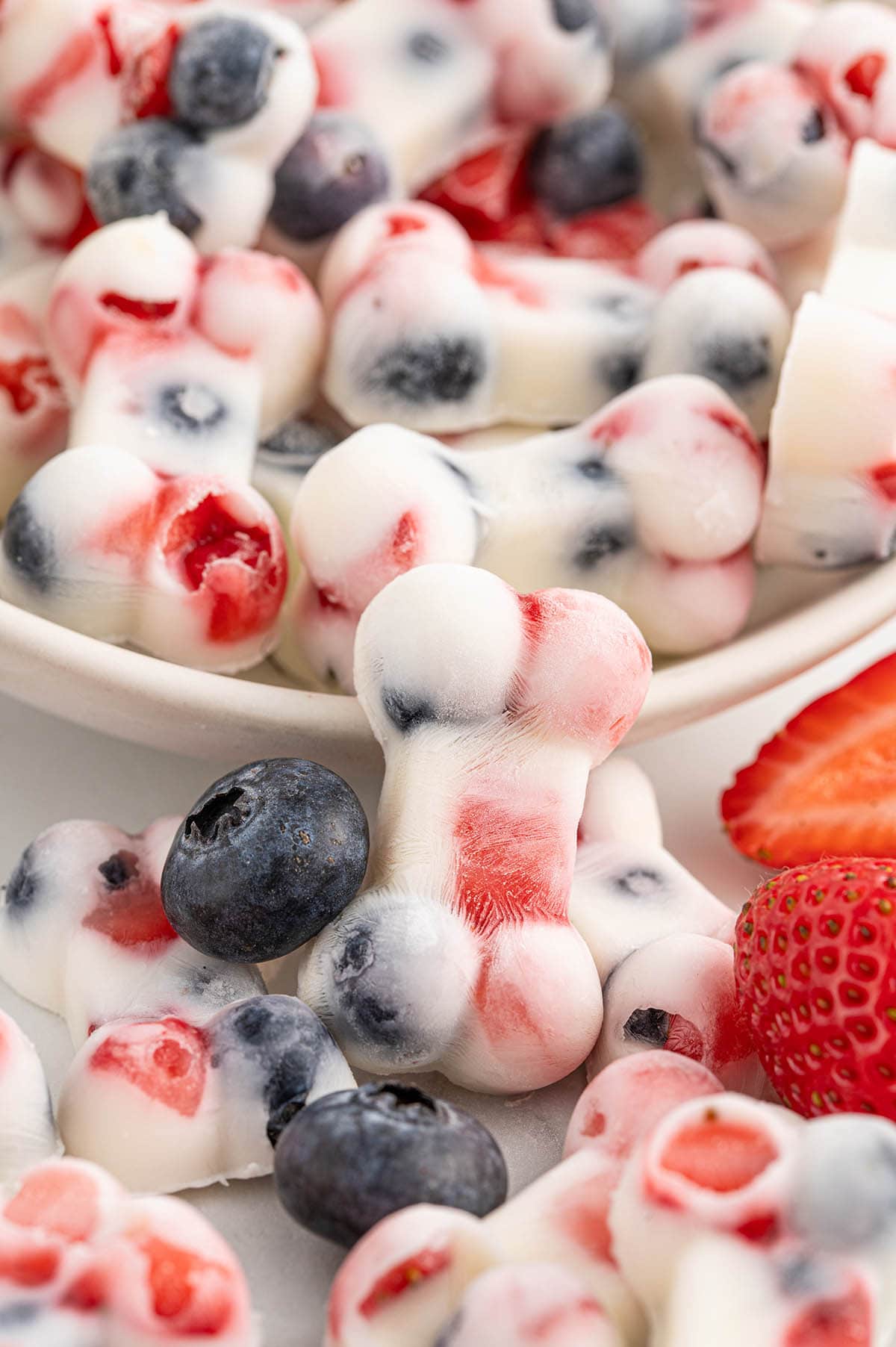 yogurt dog treats on a plate and some scattered on the table. 