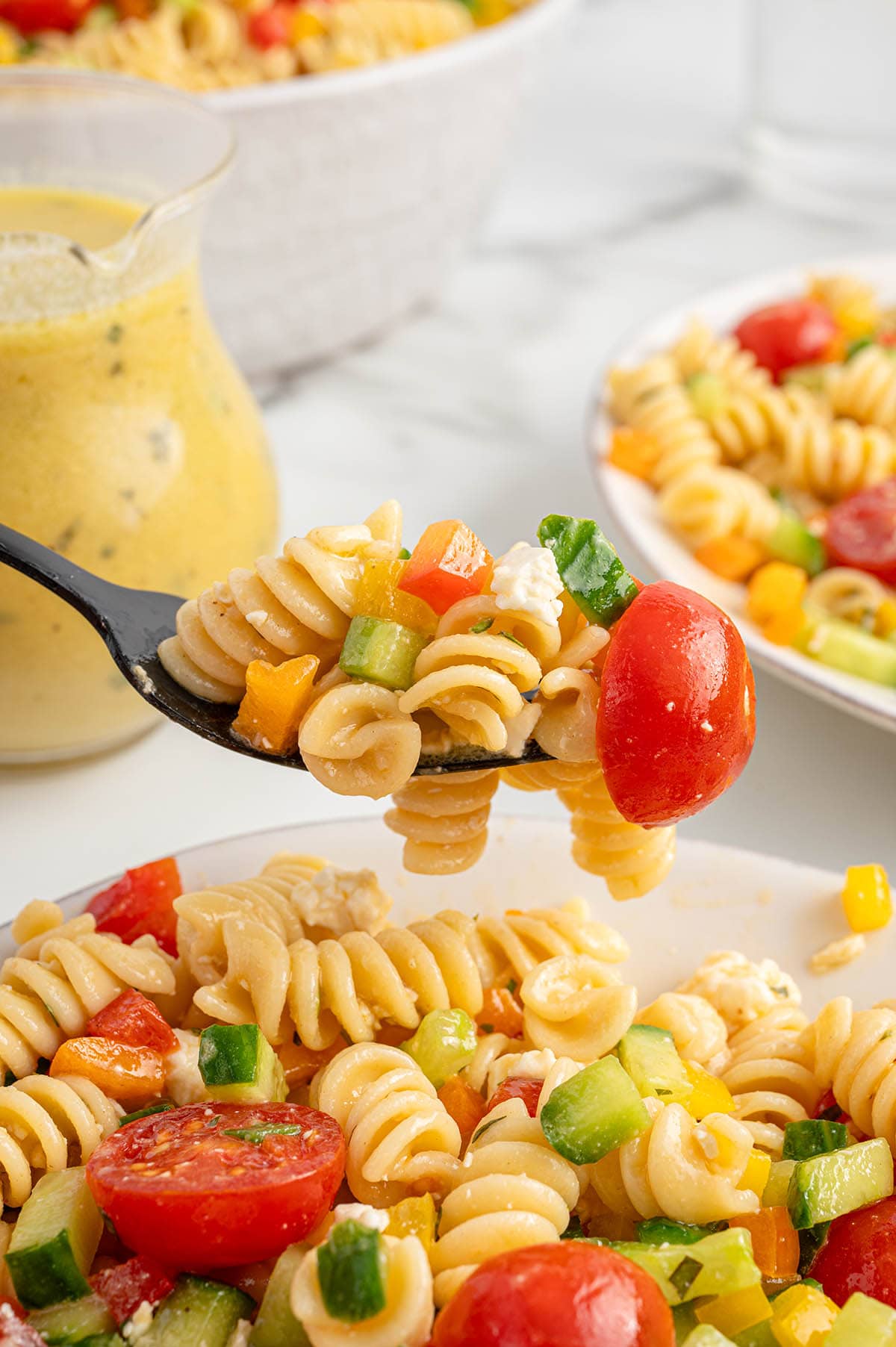 eating summer pasta salad with a fork.