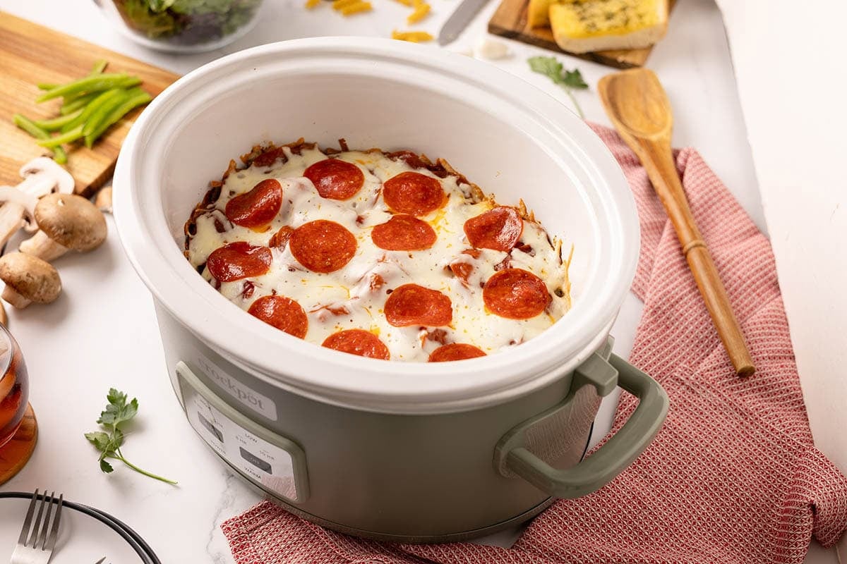 Crock pot pepperoni pizza with melted cheese in a slow cooker.