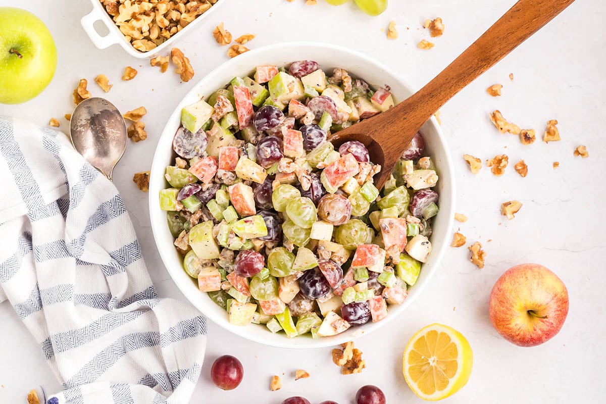 waldorf salad in a bowl with wooden spoon. 
