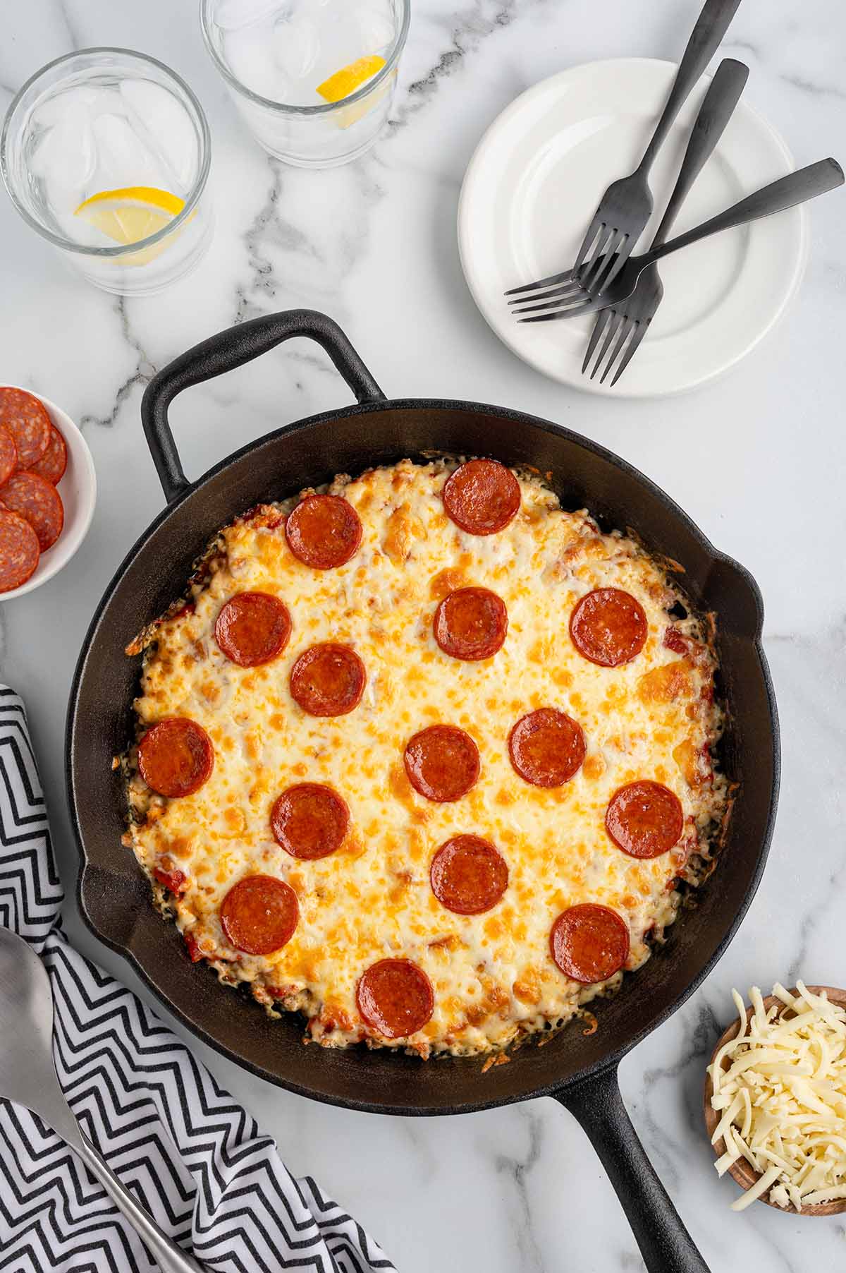 Crustless pepperoni pizza baked in a cast iron skillet, topped with melted cheese and pepperoni slices.