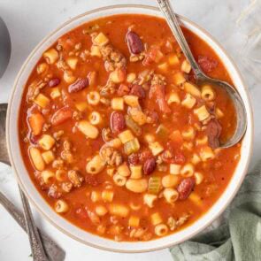 Bowl of pasta e fagioli soup with beans, pasta, beef, and veggies in tomato broth.