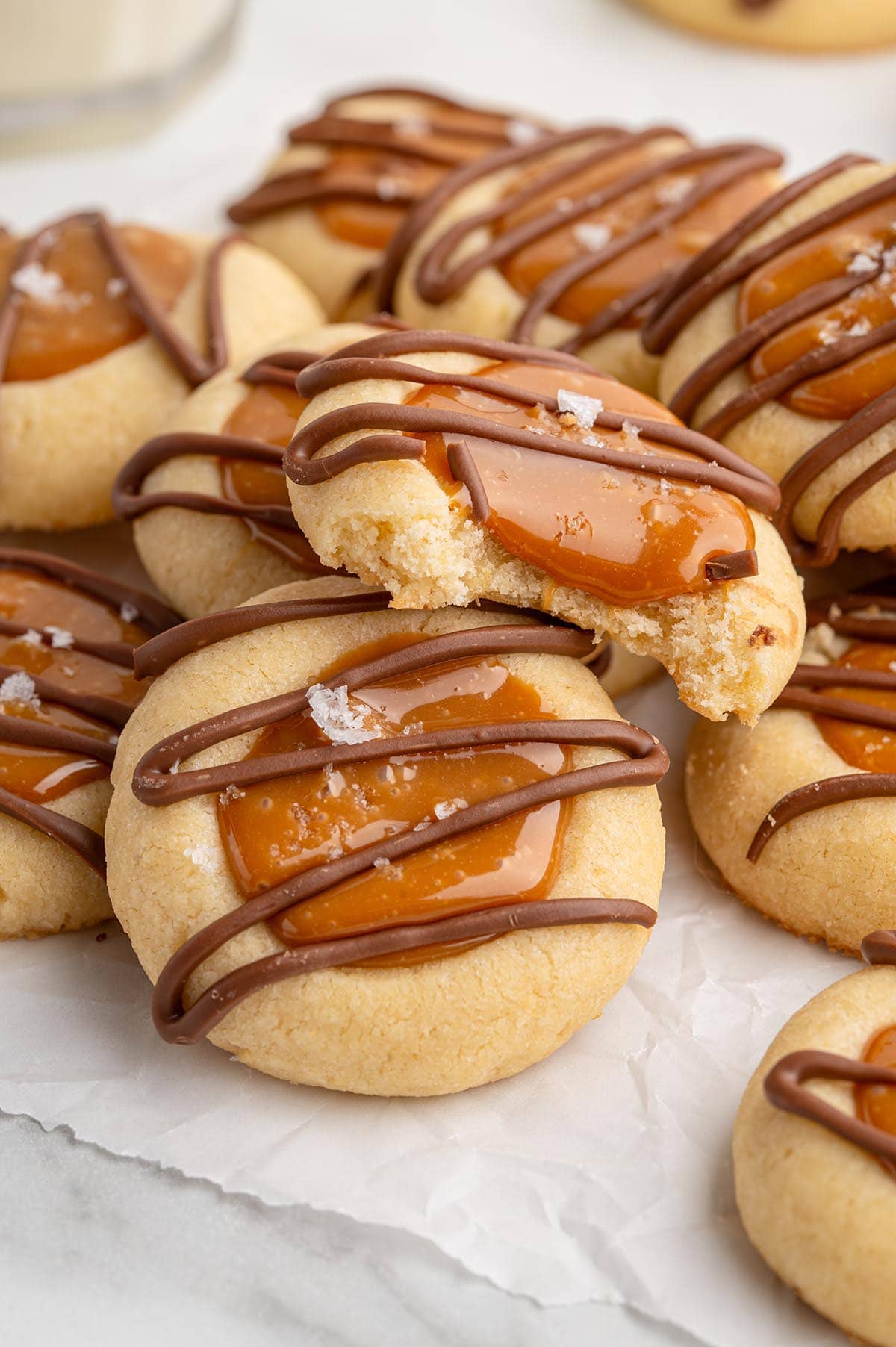 Golden Twix thumbprint cookies filled with caramel and drizzled with chocolate