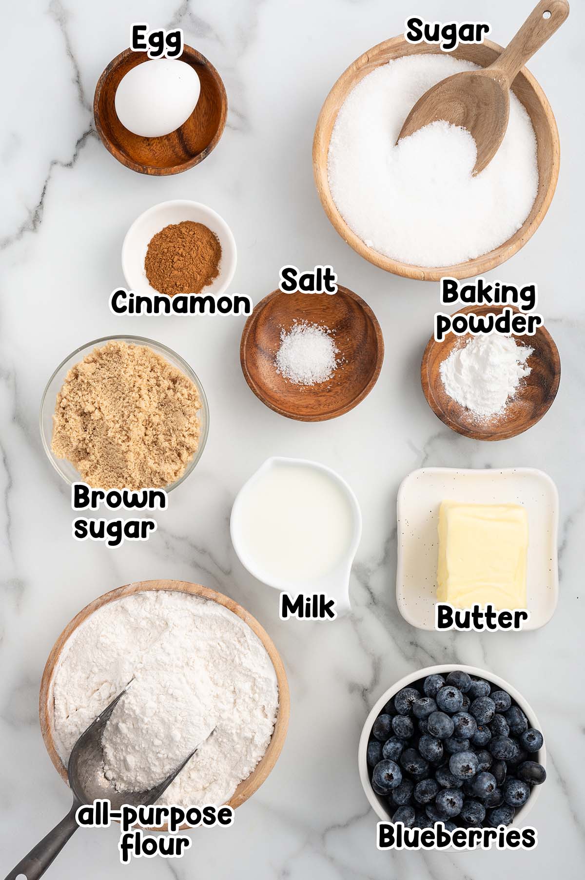 Flatlay of blueberry coffee cake ingredients including blueberries, coffee, sugar, flour and butter.