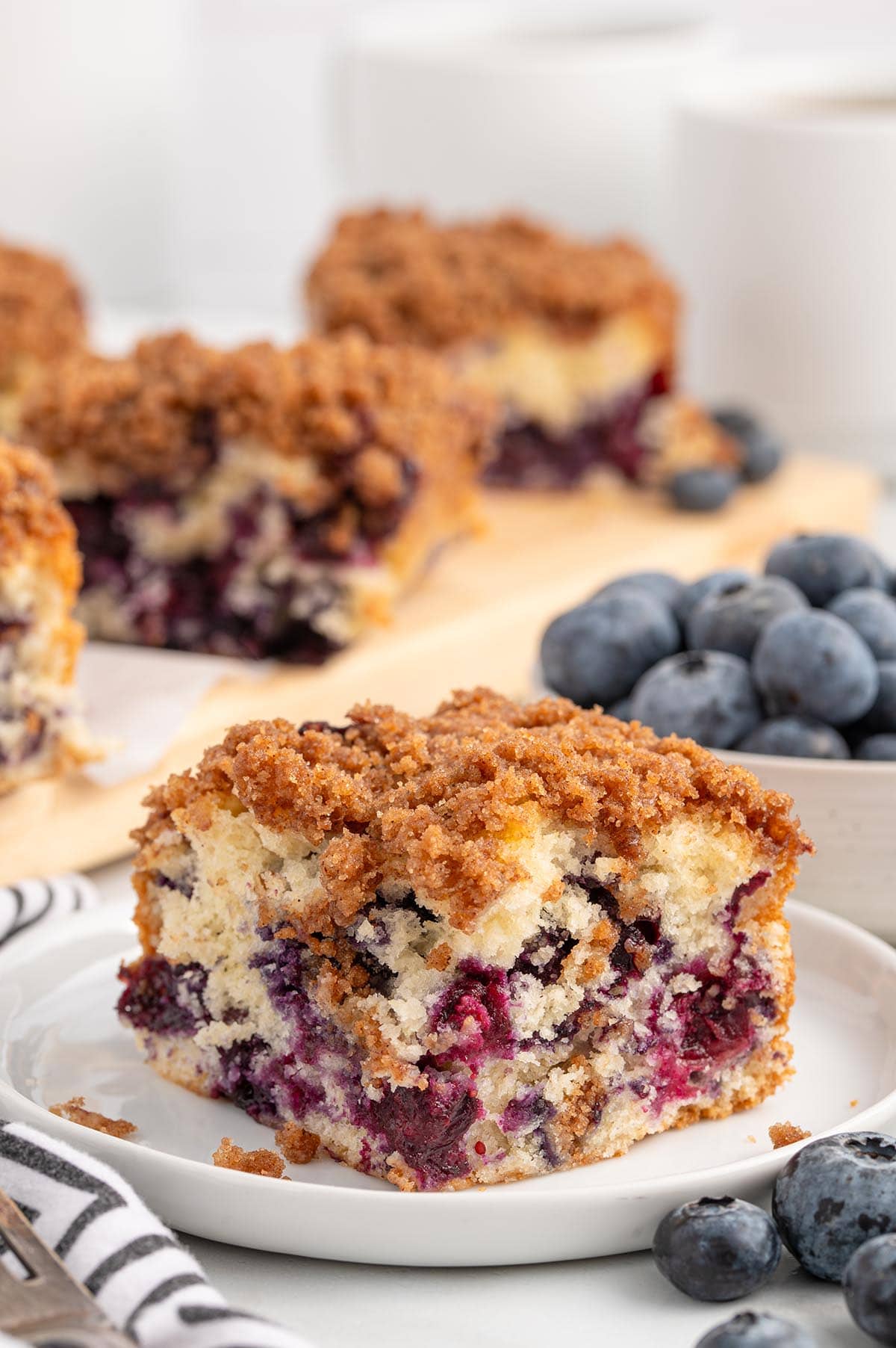 A slice of Blueberry coffee cake on a white plate
