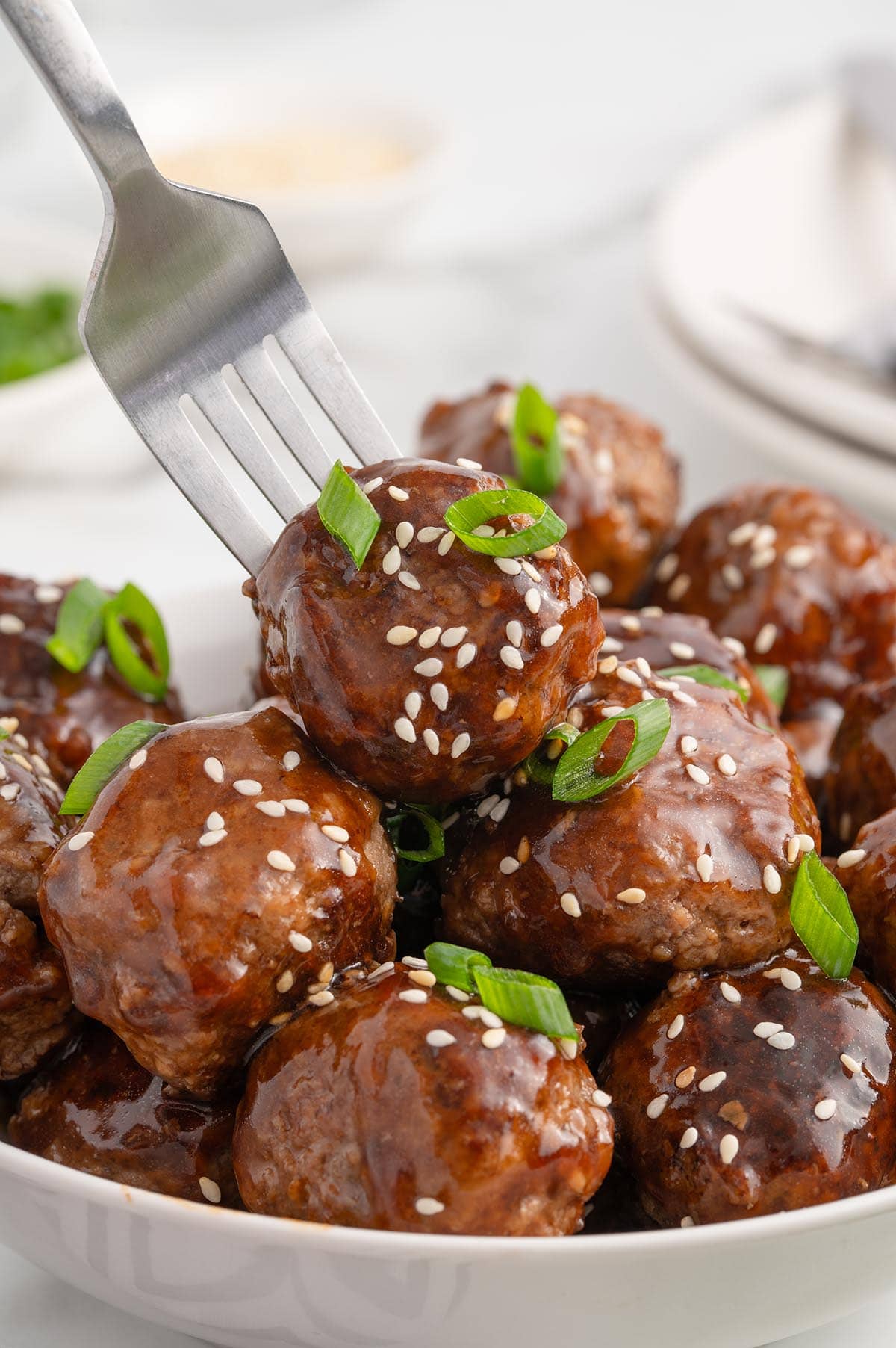 teriyaki meatballs served in a bowl with sesame seeds. 