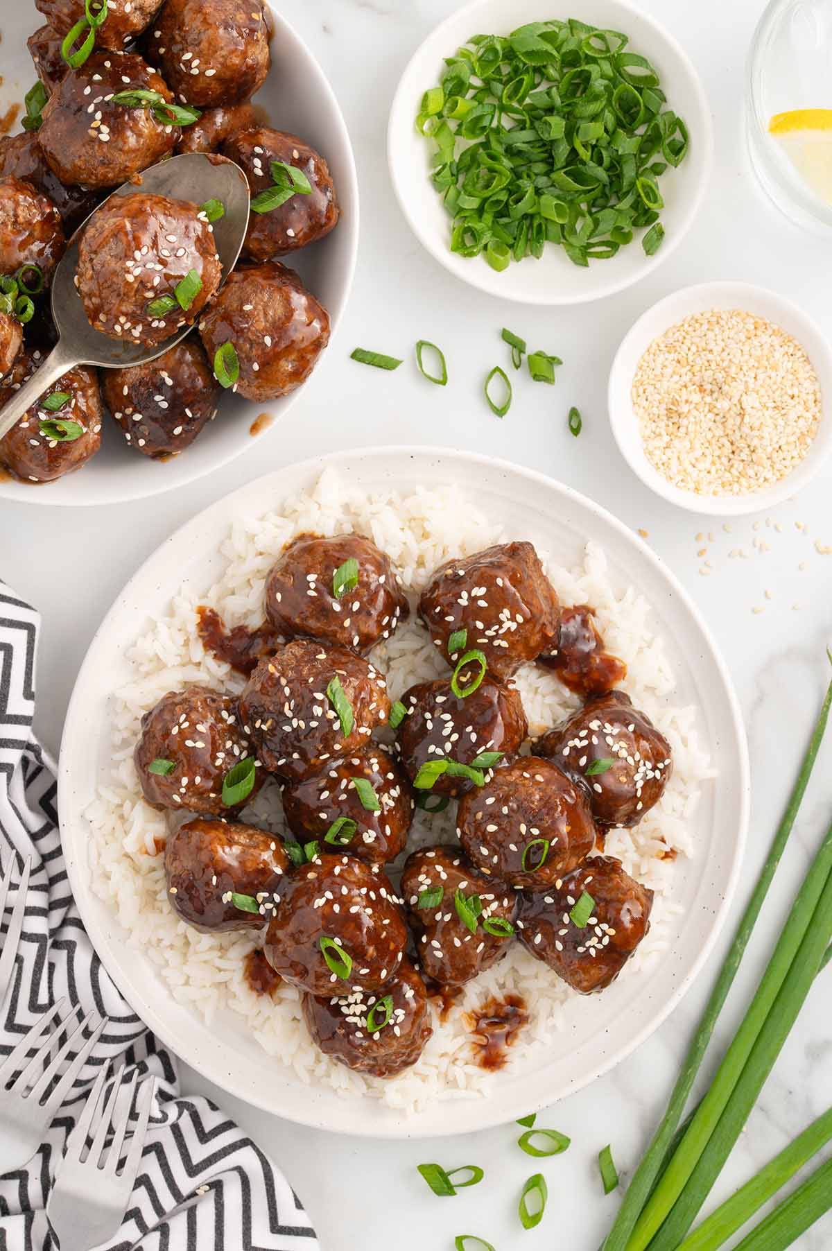 teriyaki meatballs served on a plate full of rice.