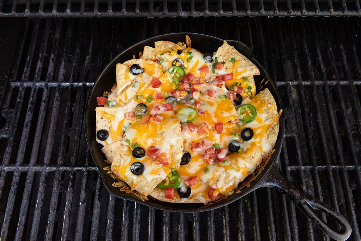 campfire nachos in a skillet on top of grill. 
