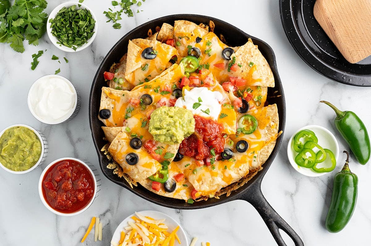 campfire nachos in a skillet on top of table. 