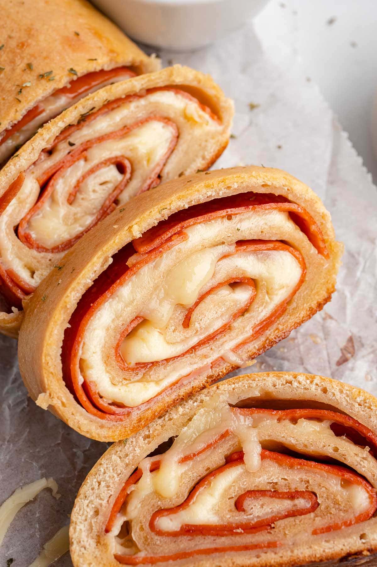 Freshly baked pepperoni rolls sliced to show pepperoni and gooey cheese layers.