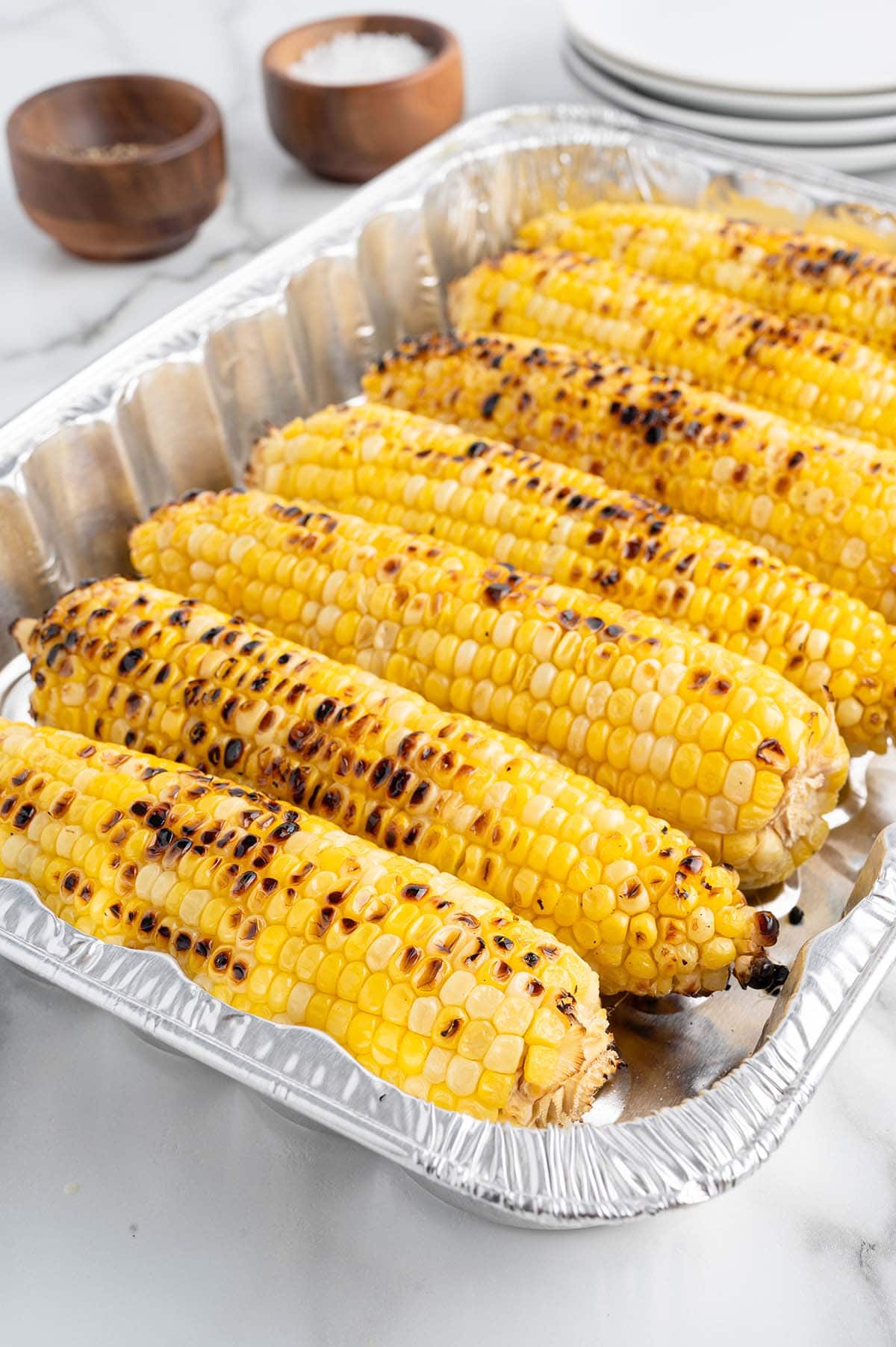 Freshly grilled corn with a golden yellow color and dark spots from the grill.