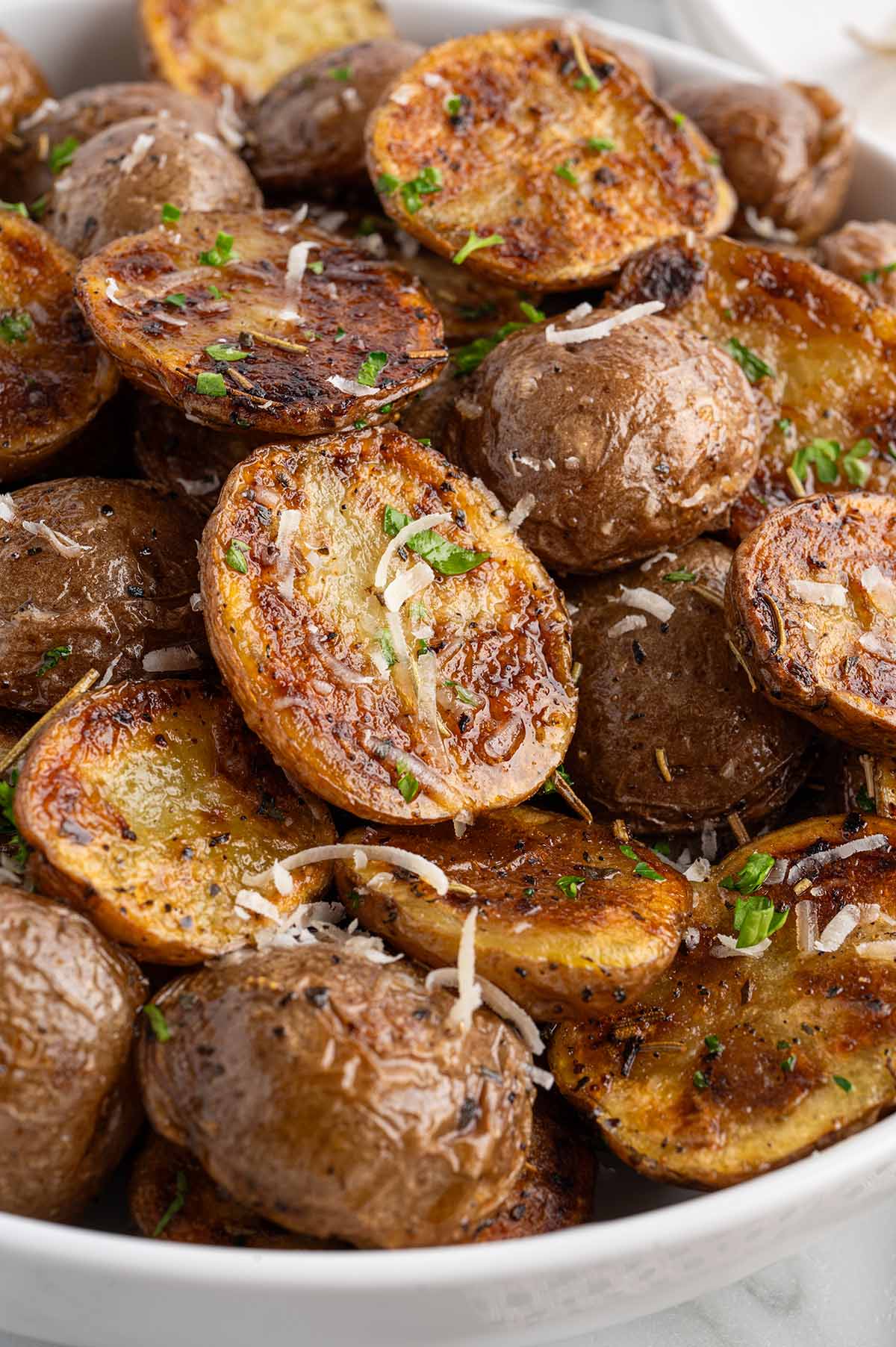 A bowl of golden, perfectly grilled potatoes with a light dusting of seasoning.
