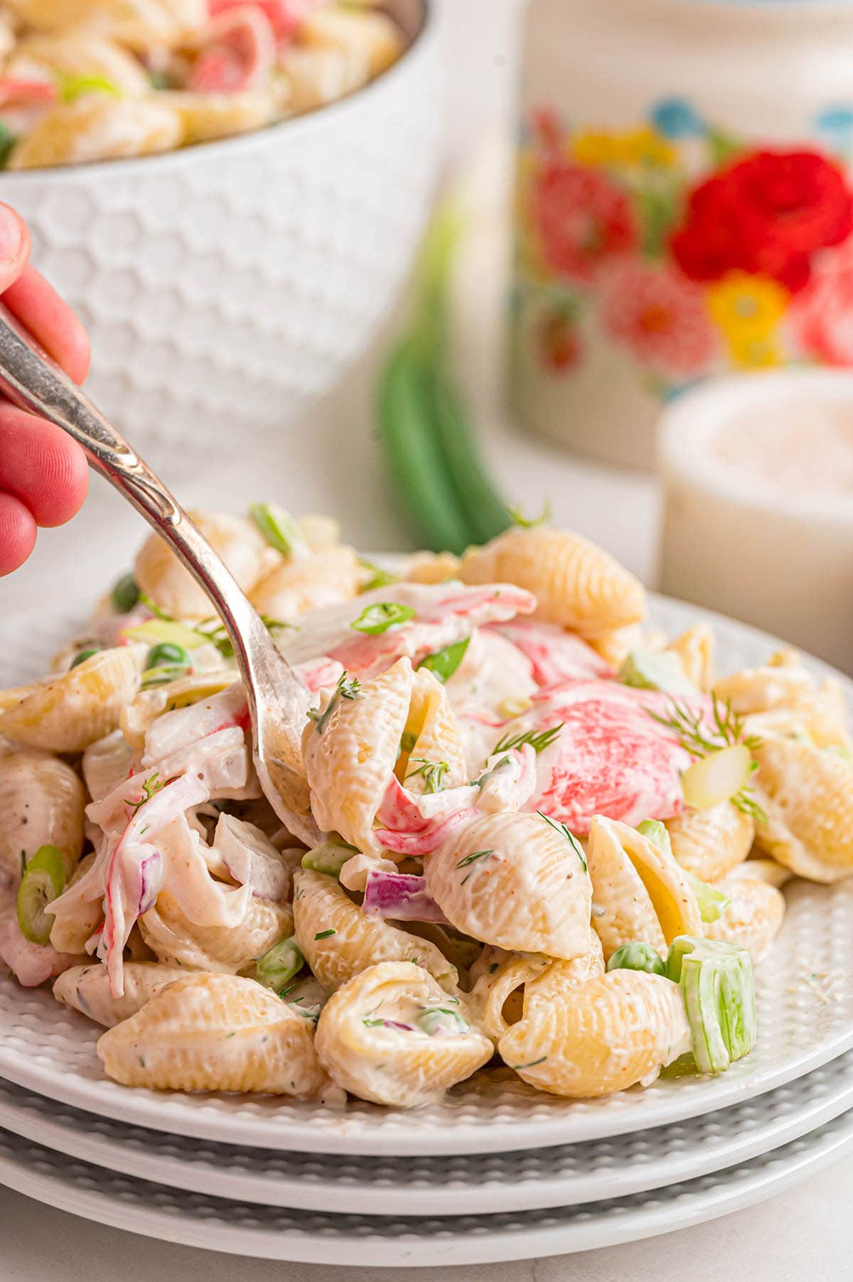 A creamy and fresh pasta salad with crab meat and herbs on a plate.