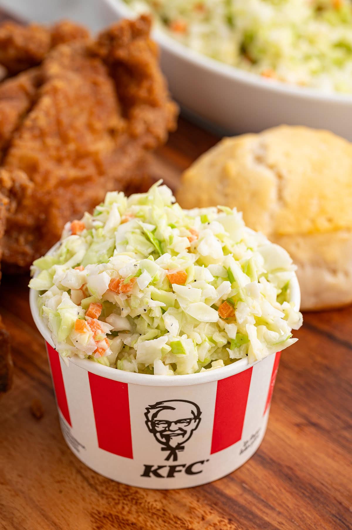 A cup of KFC-style coleslaw with shredded cabbage and carrots.