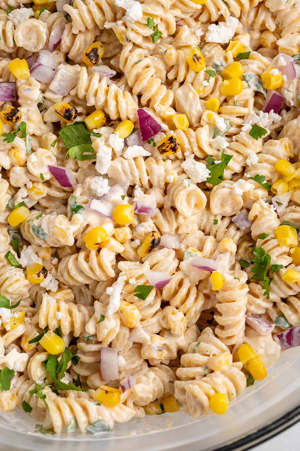 Pasta salad loaded with smoky grilled corn, red onion, and fresh parsley.