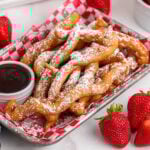 Funnel cake fries dusted with powdered sugar served with chocolate sauce.