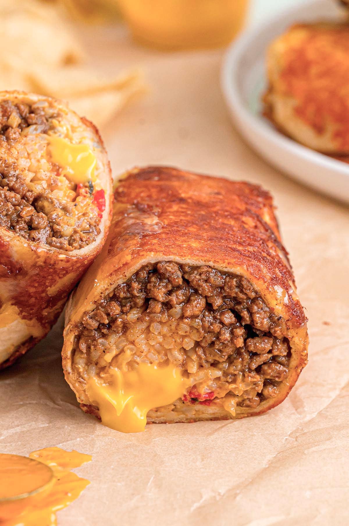 Close-up of a crispy grilled cheese burrito with gooey cheese oozing from the center.