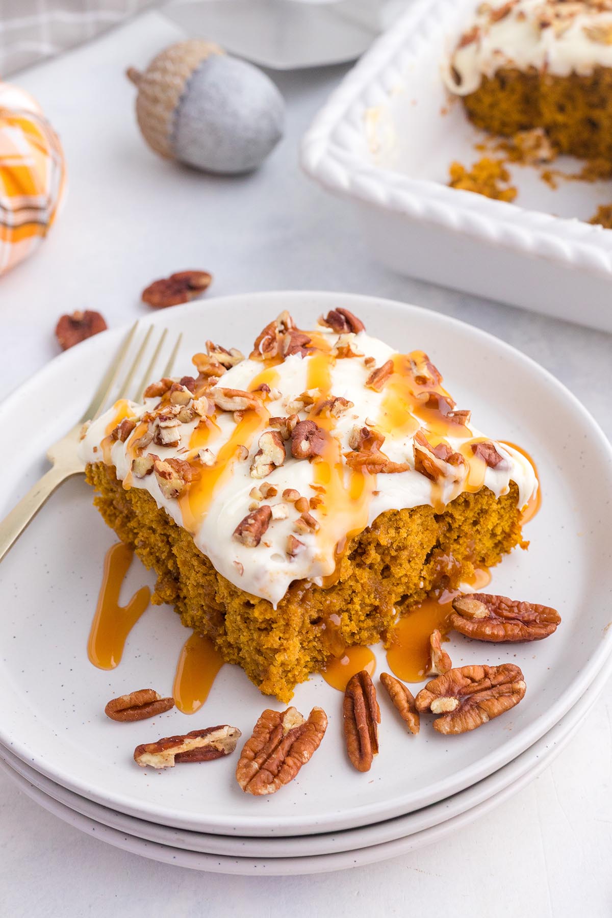Soft, spiced pumpkin cake with thick icing and crunchy pecan pieces.