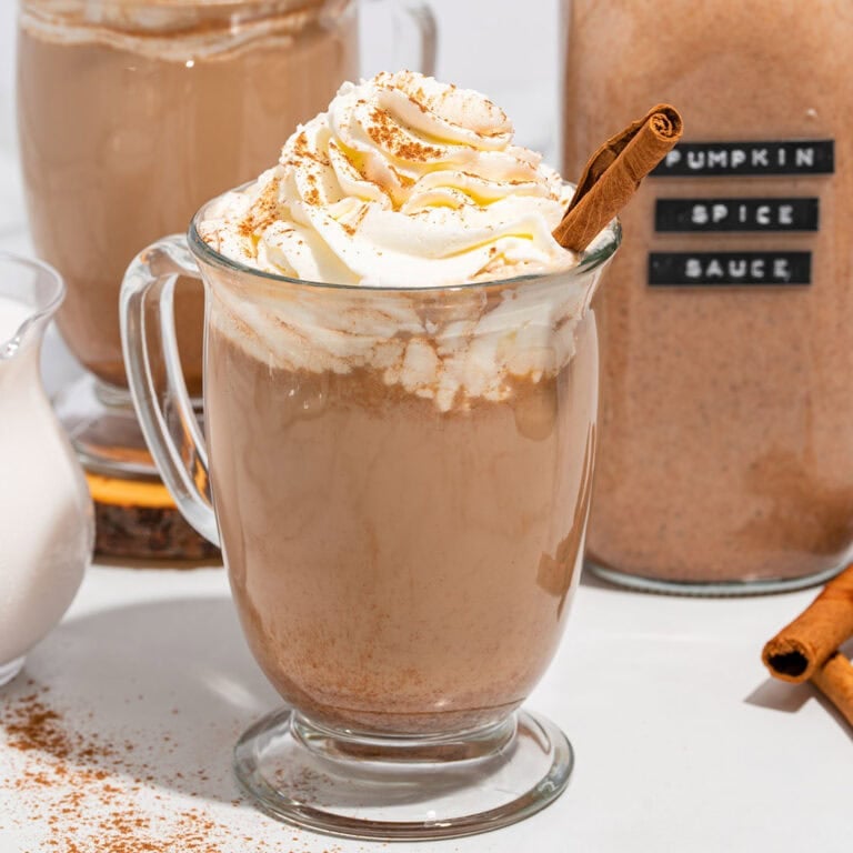 pumpkin spice latte in a glass with whipped topping.