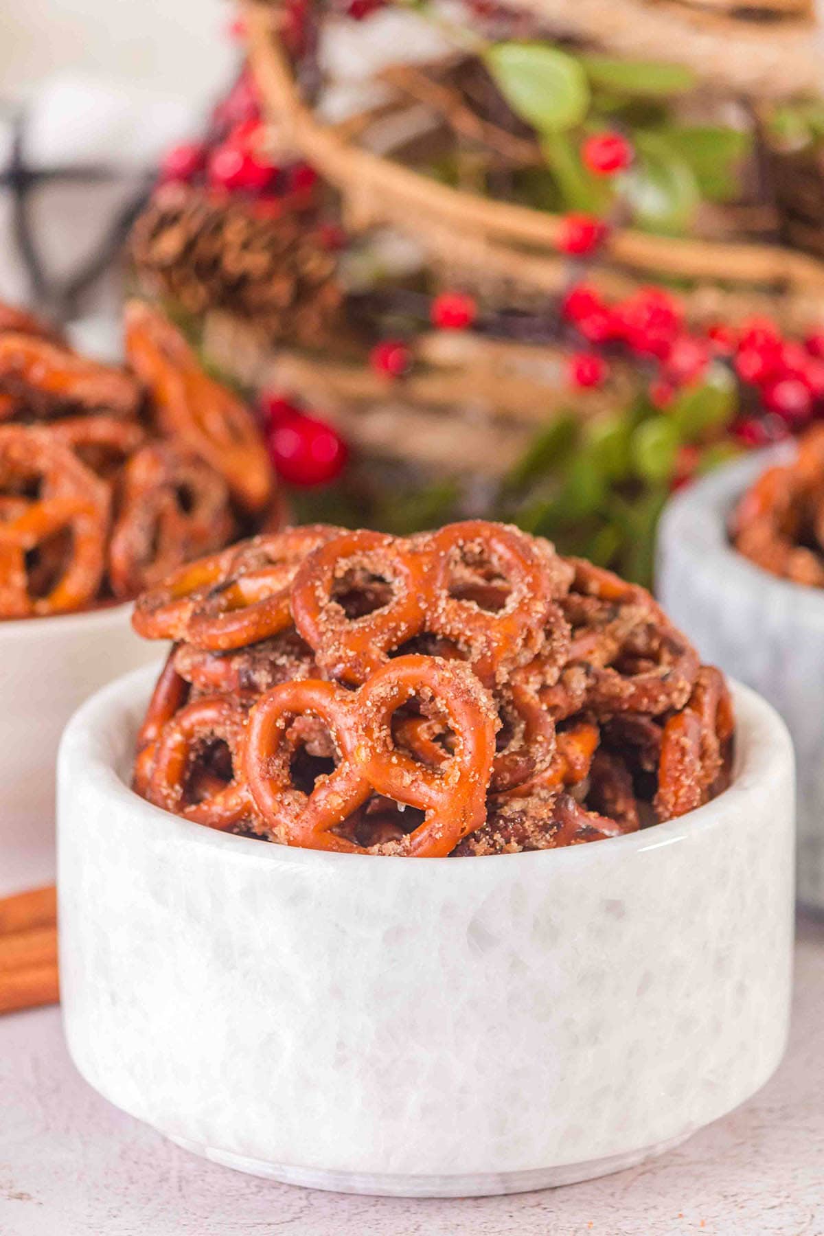 Pretzels coated with cinnamon sugar sitting in a textured ceramic bowl.
