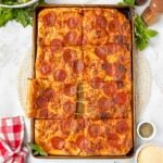 A fresh sheet pan pizza topped with melted cheese and pepperoni slices.
