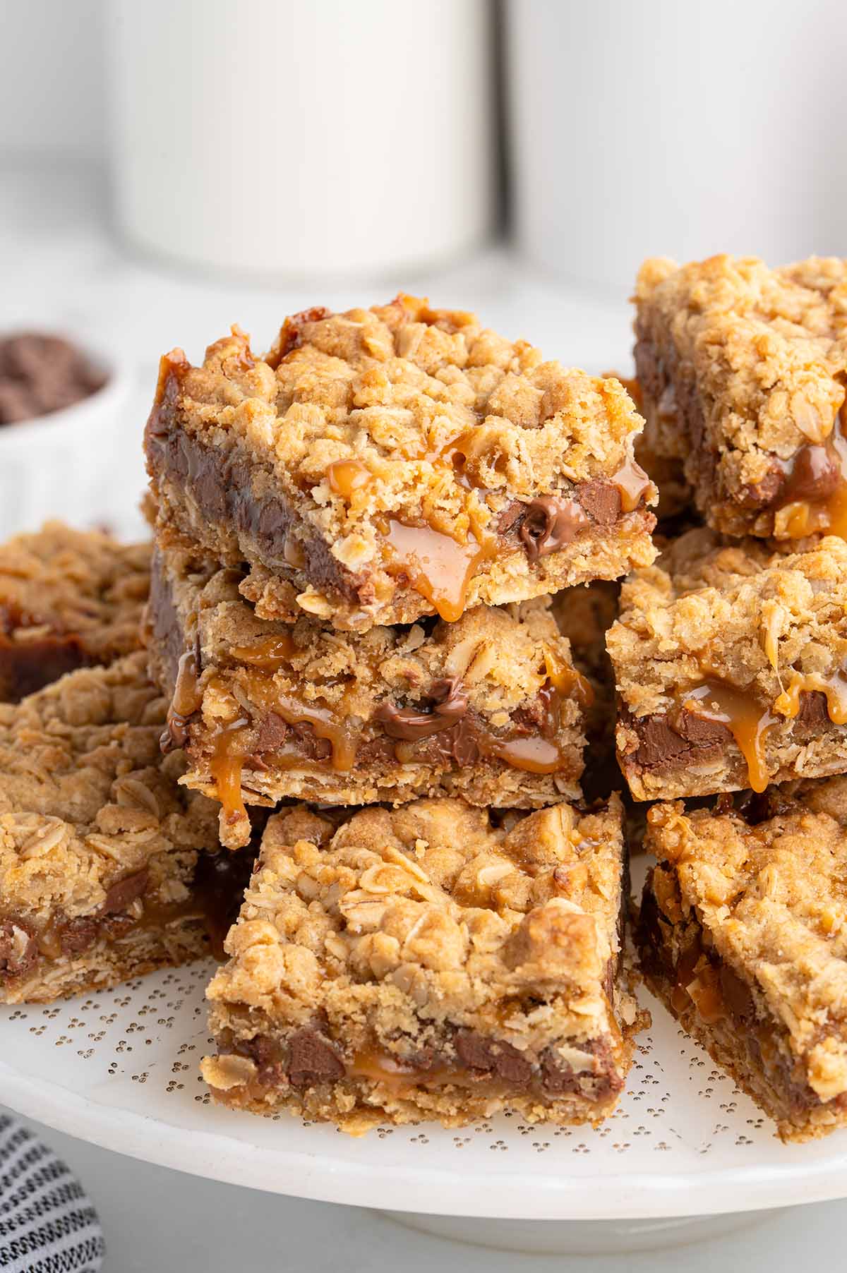 A stack of fresh carmelitas with melted caramel dripping slightly.