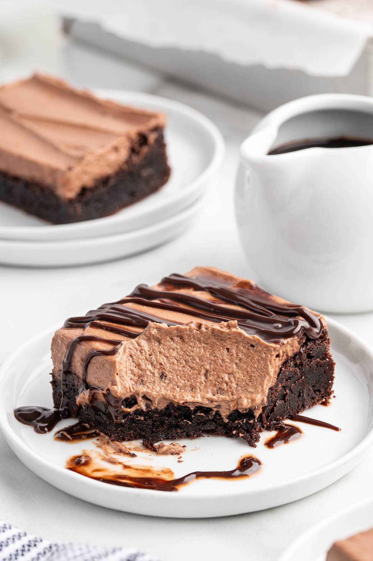 Creamy chocolate mousse brownies served on a white plate