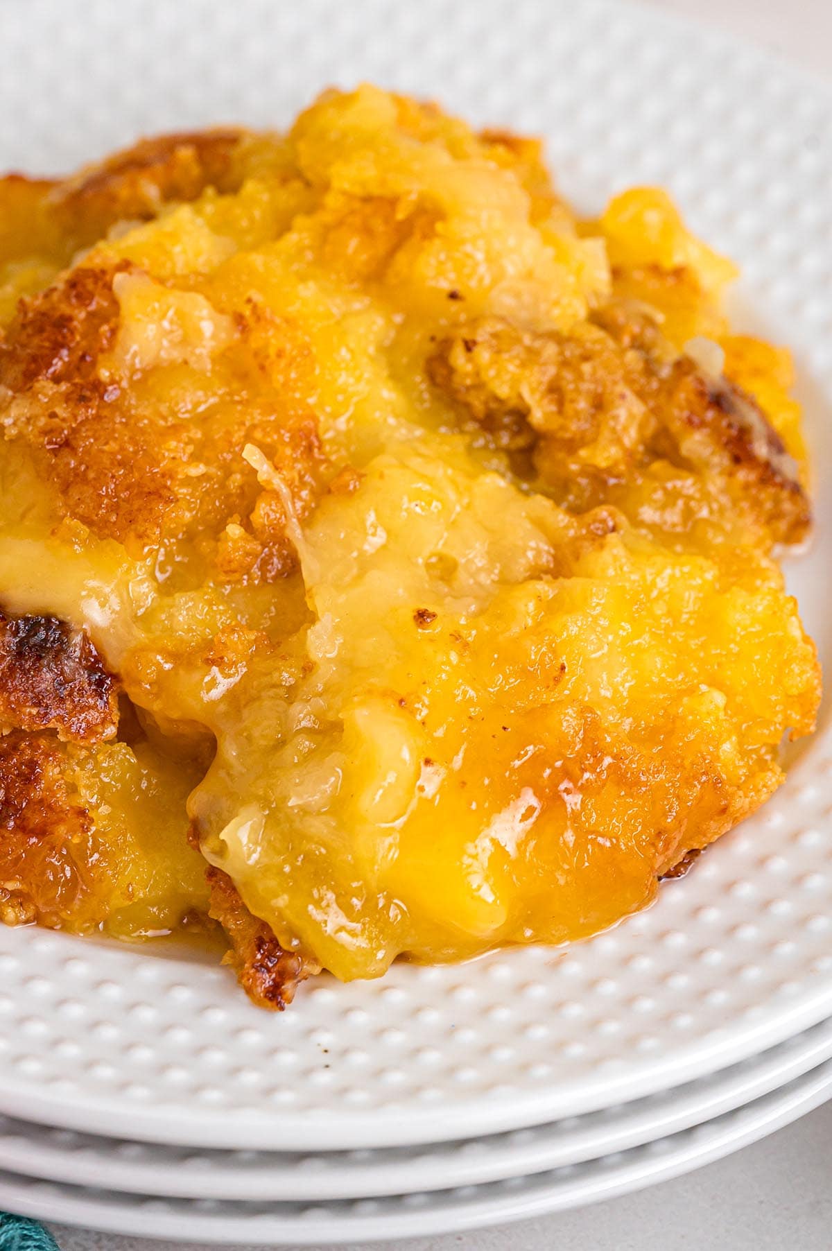 Close up of pineapple dump cake served on a white plate