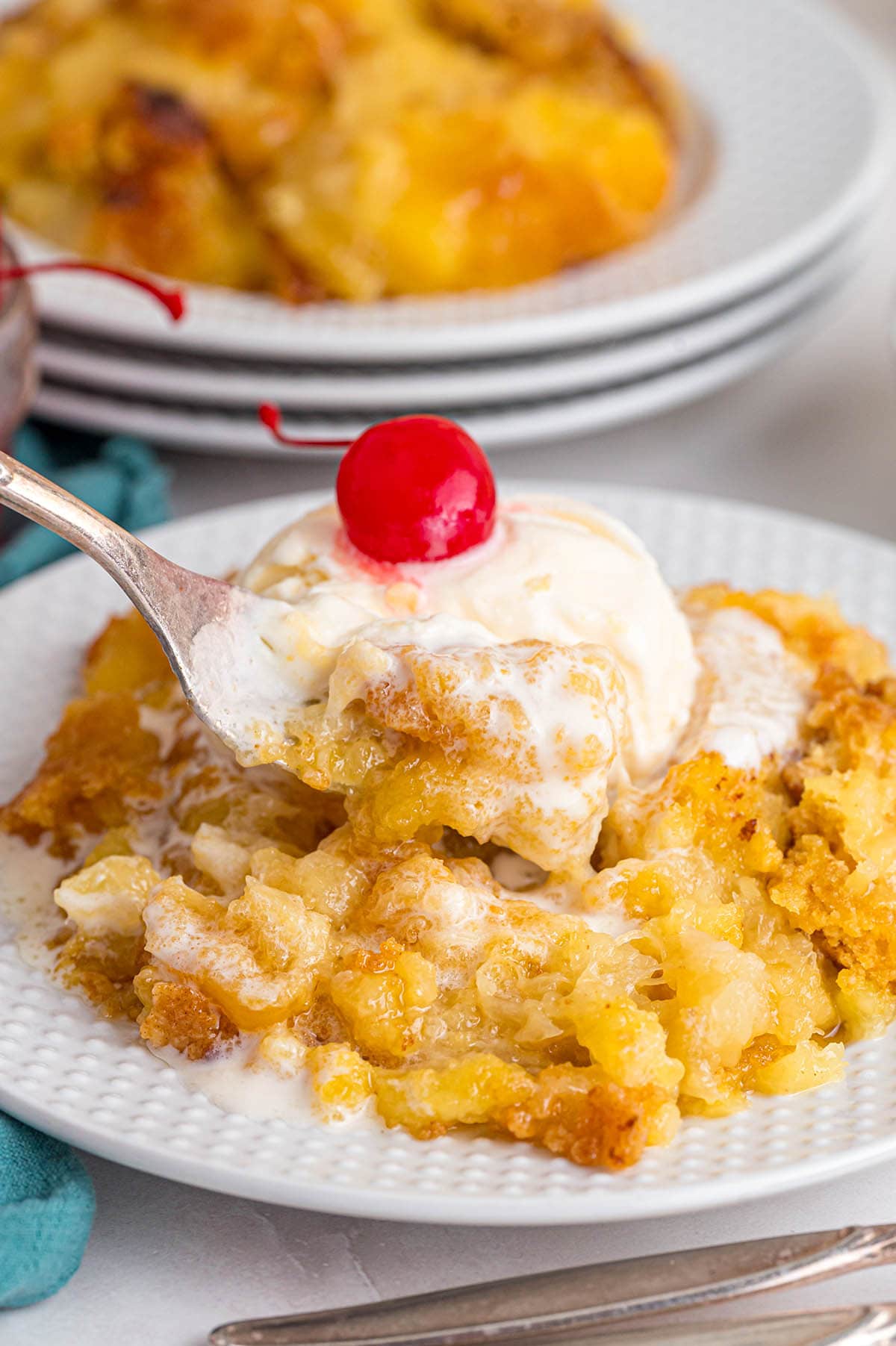 A spoon digging into pineapple dump cake