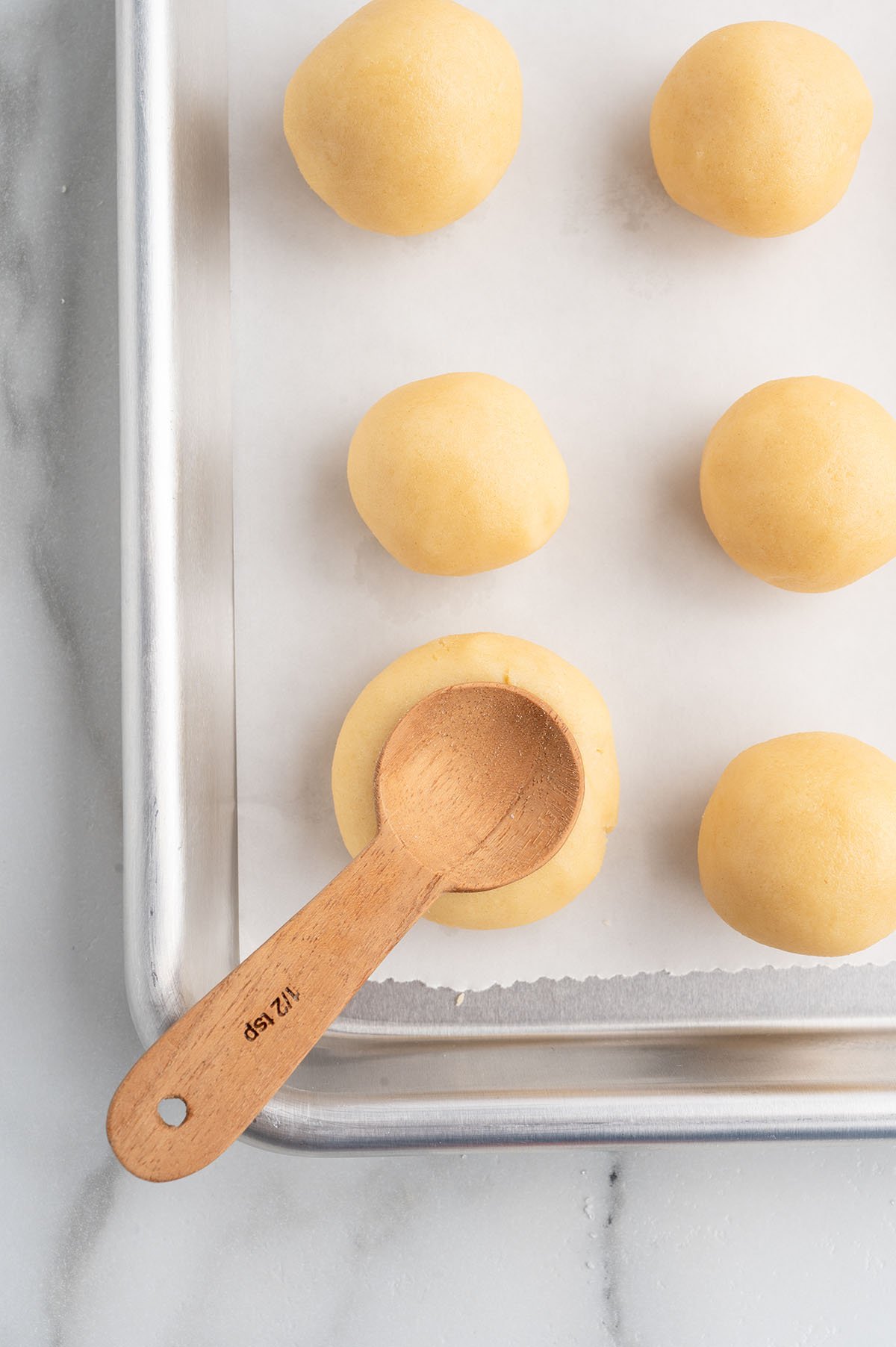 Twix thumbprint cookies cookie dough ball pressed with a wooden spoon