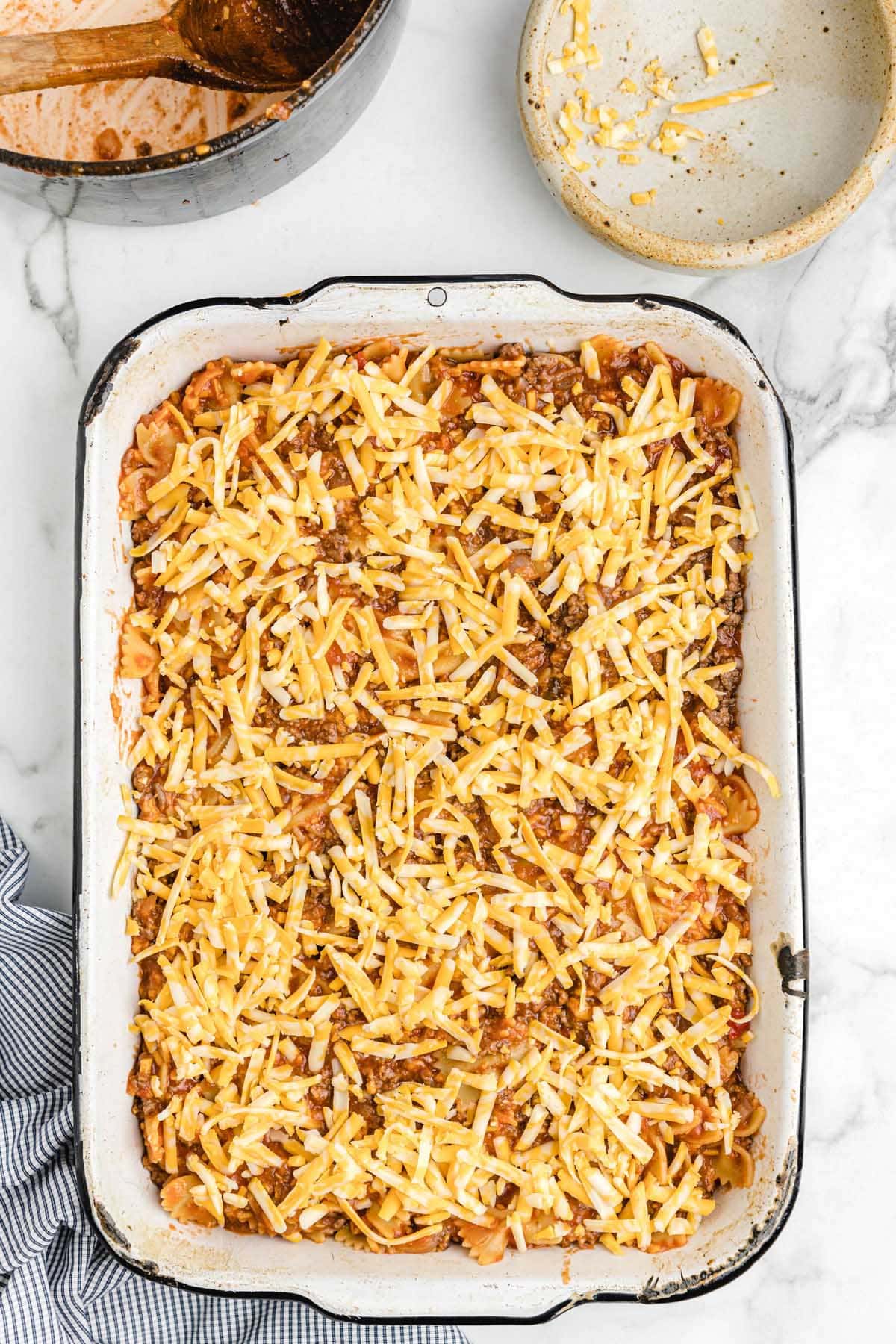 sloppy joe casserole in a baking dish with cheese sprinkled on top.