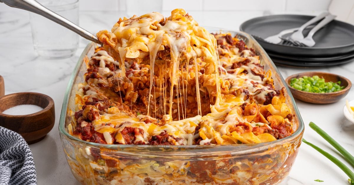 Cheesy Sour Cream Noodle Bake made from egg noodles served in a glass baking dish.