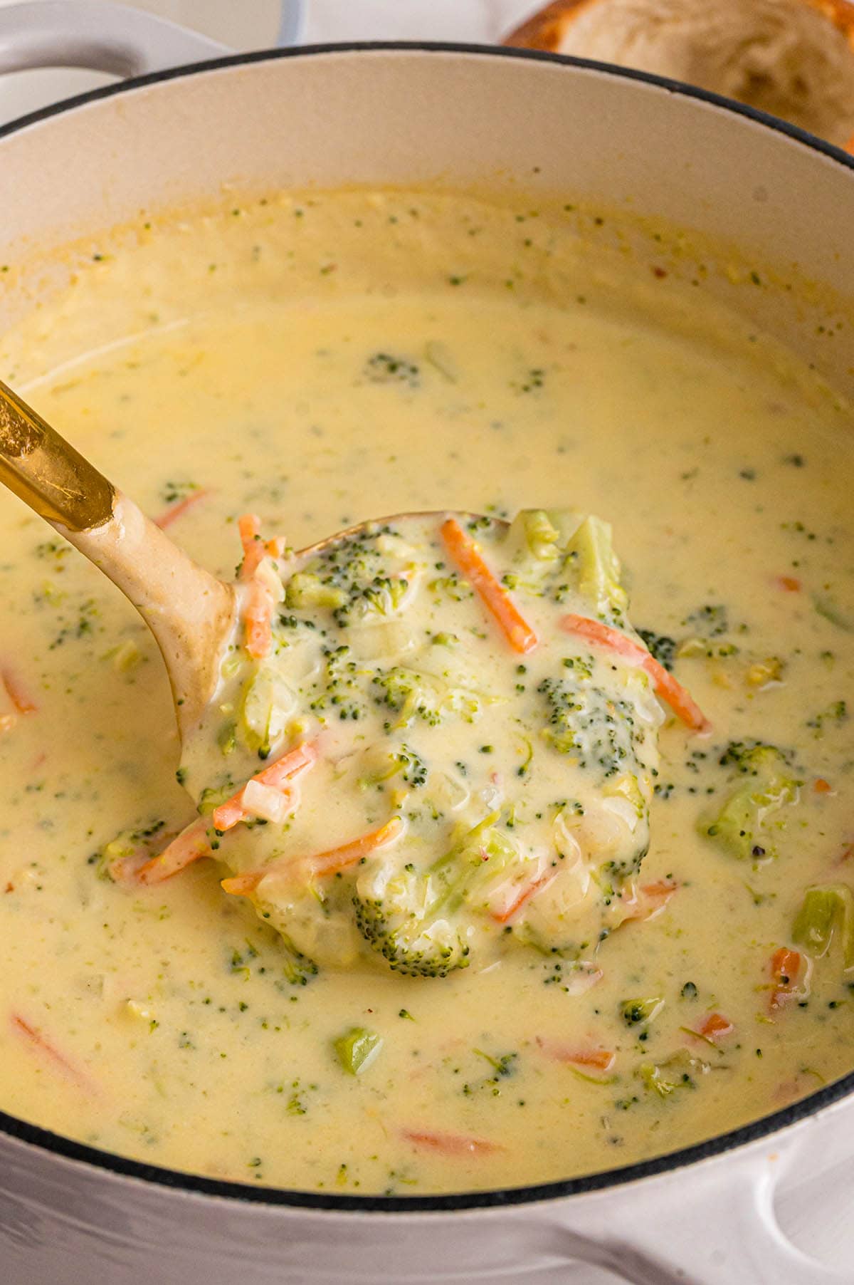 Creamy Panera broccoli cheddar soup fills a white pot.