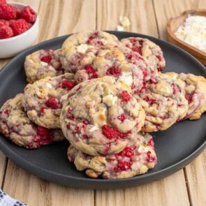 white chocolate raspberry cookies on top of black plate.