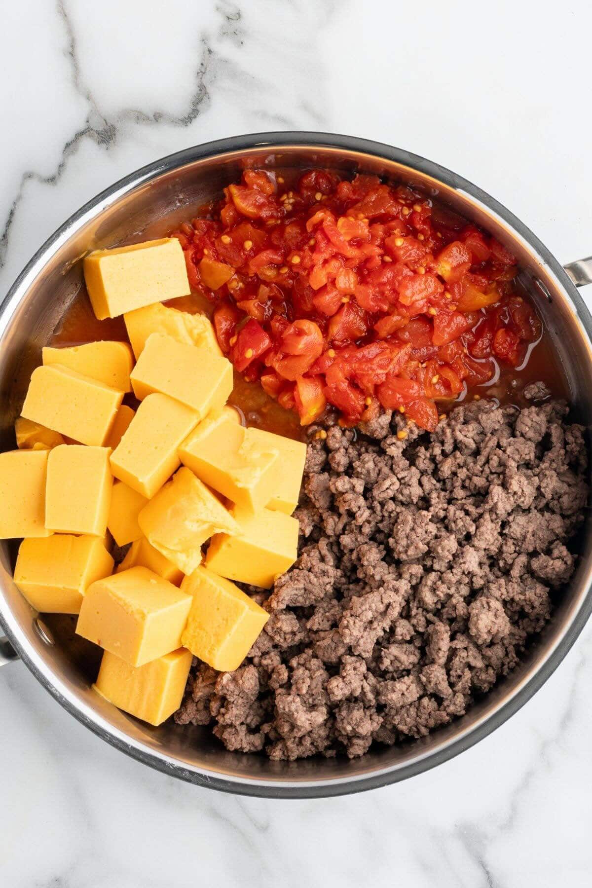add cheese and tomatoes in the pan with the browned beef.