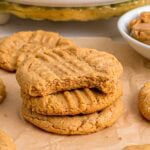 3 ingredient peanut butter cookies stacked on top of parchment paper.
