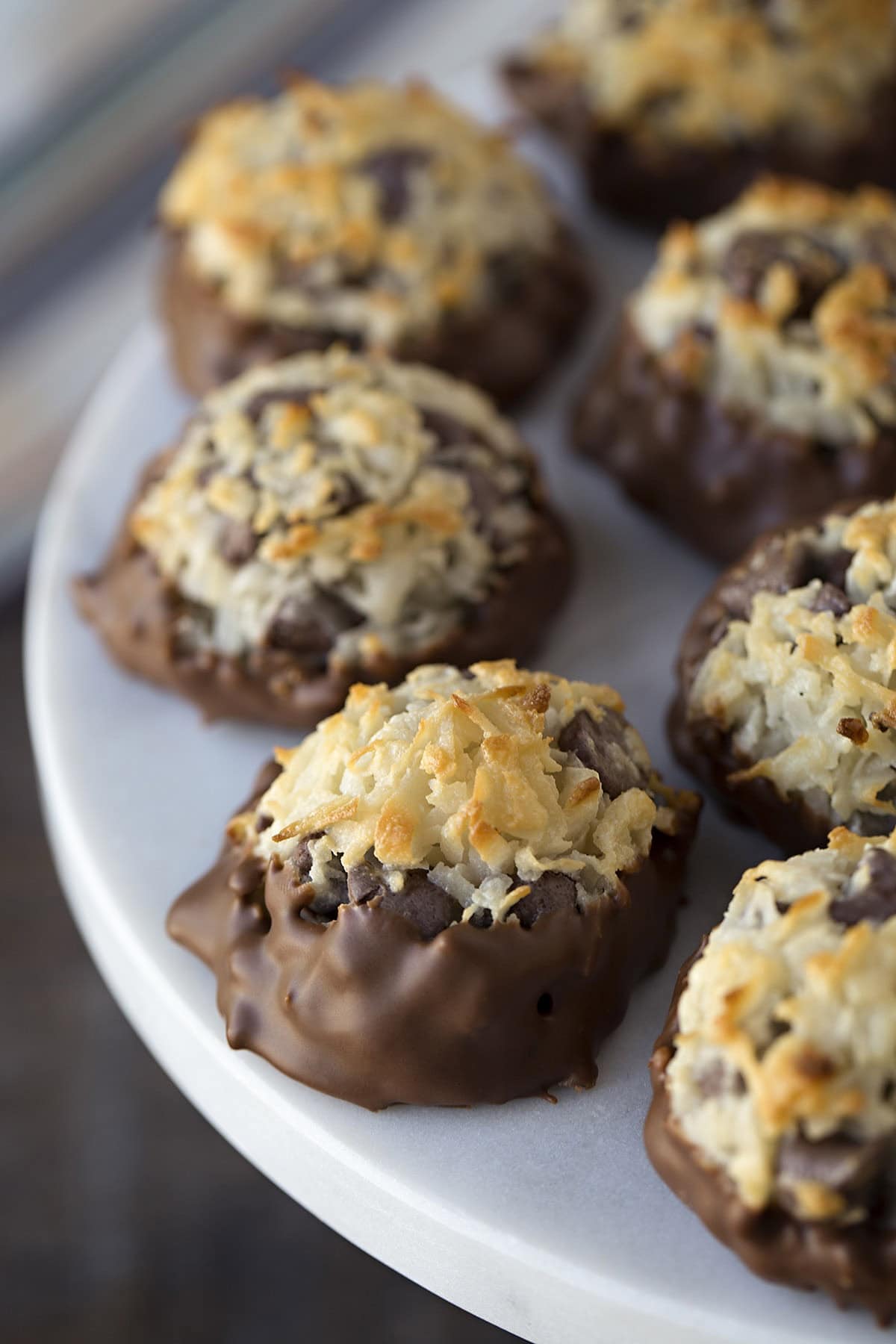 Stack of coconut macaroons with chocolate chips and dark chocolate bottoms.