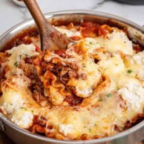 pan with noodles and cheese with a wooden spoon scooping