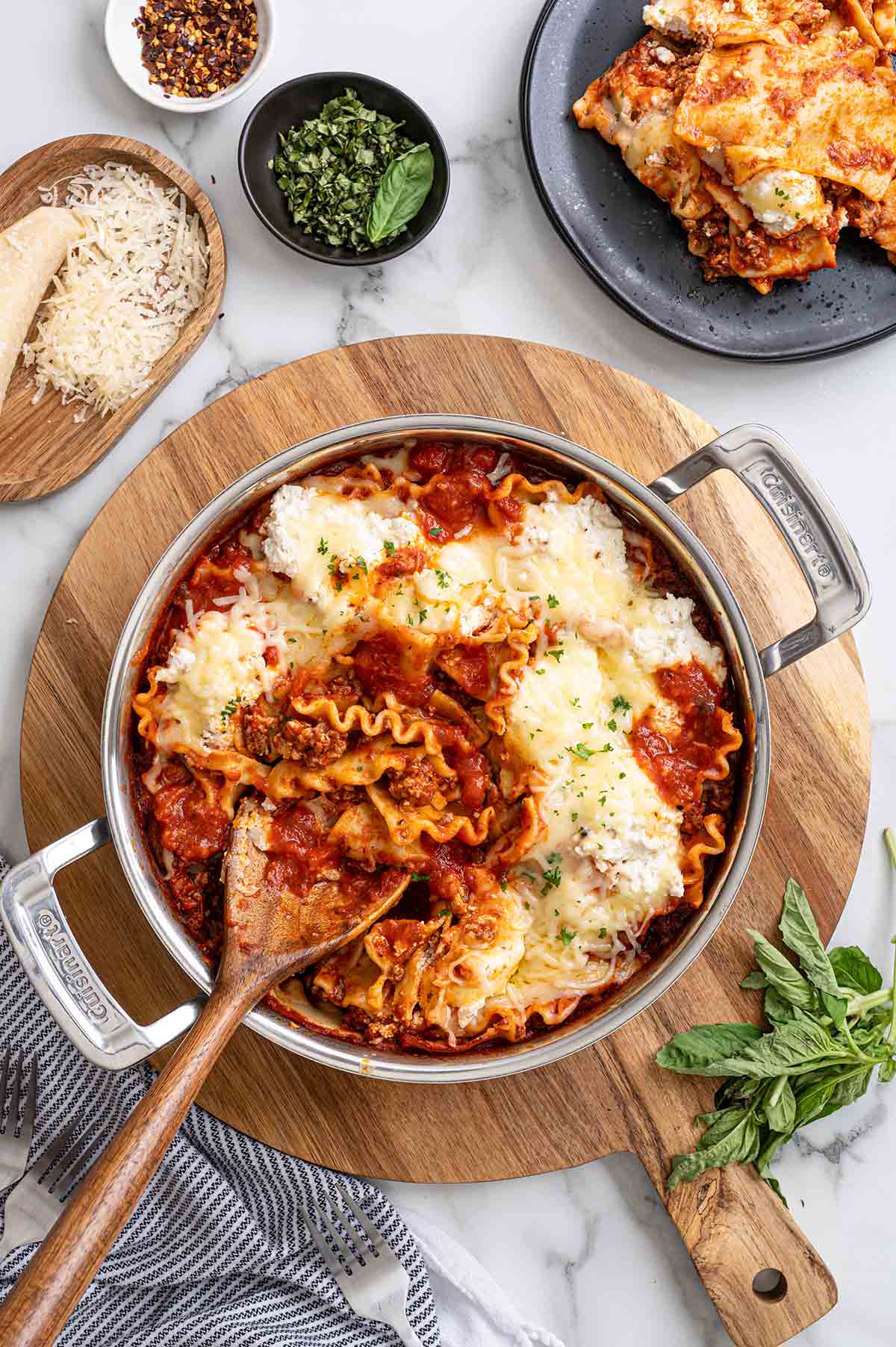 Skillet lasagna with melted cheese, tomato sauce, and fresh basil on top.