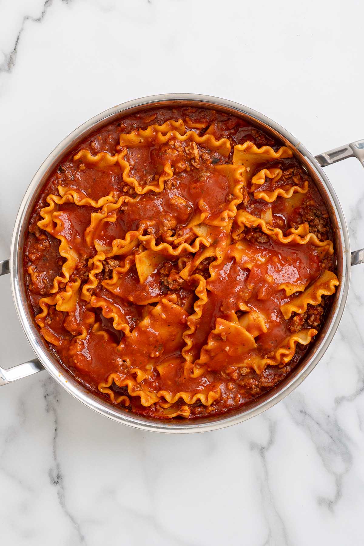 add the noodles and pasta sauce into the skillet. 