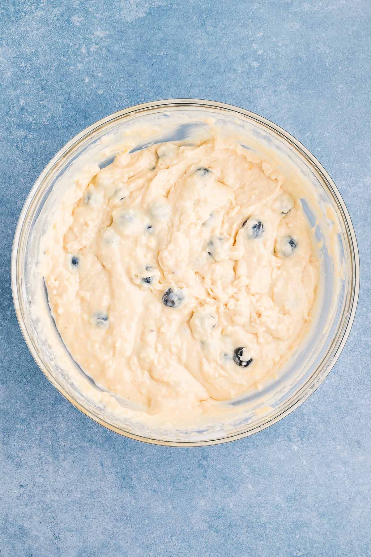 adding blueberries into the dough mixture. 