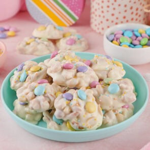 white chocolate crockpot candy on pastel blue plate.