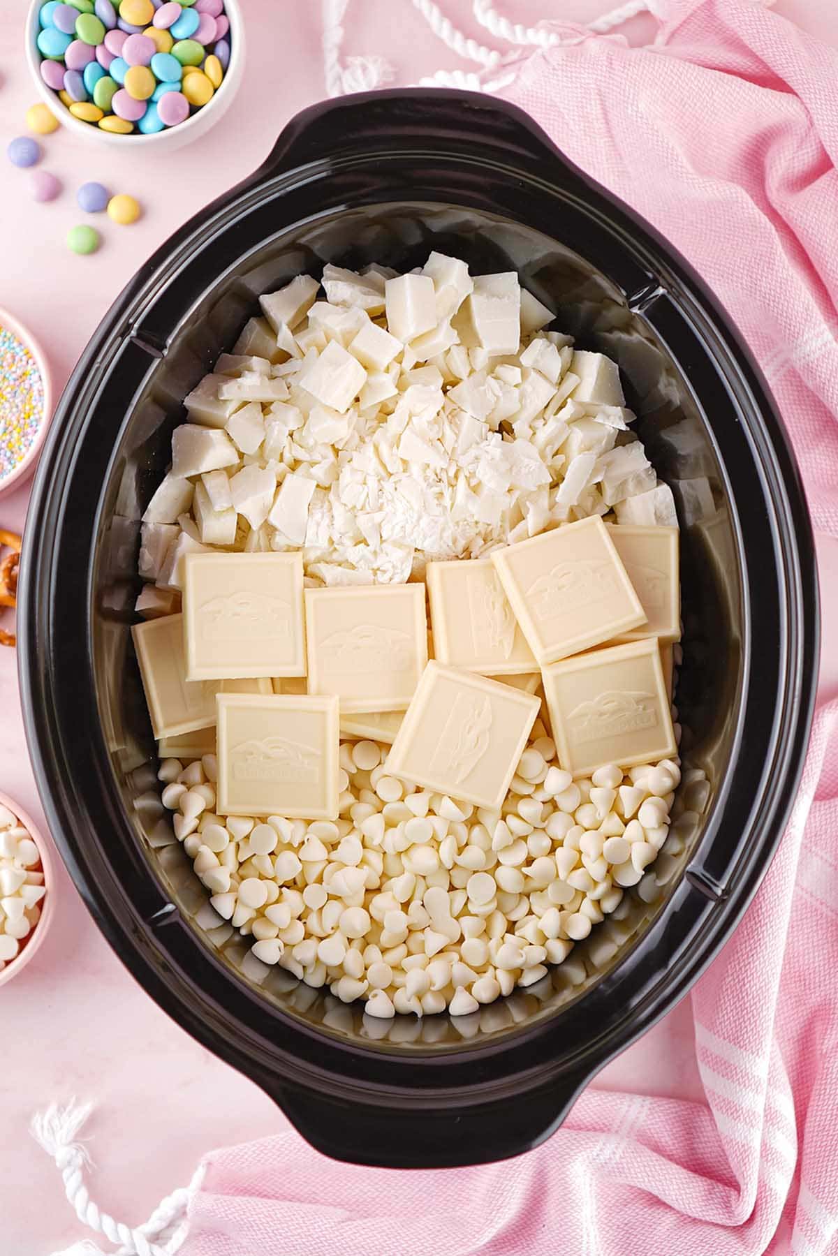 place the peanuts, white chocolate chips and white chocolate bars inside the crockpot. 