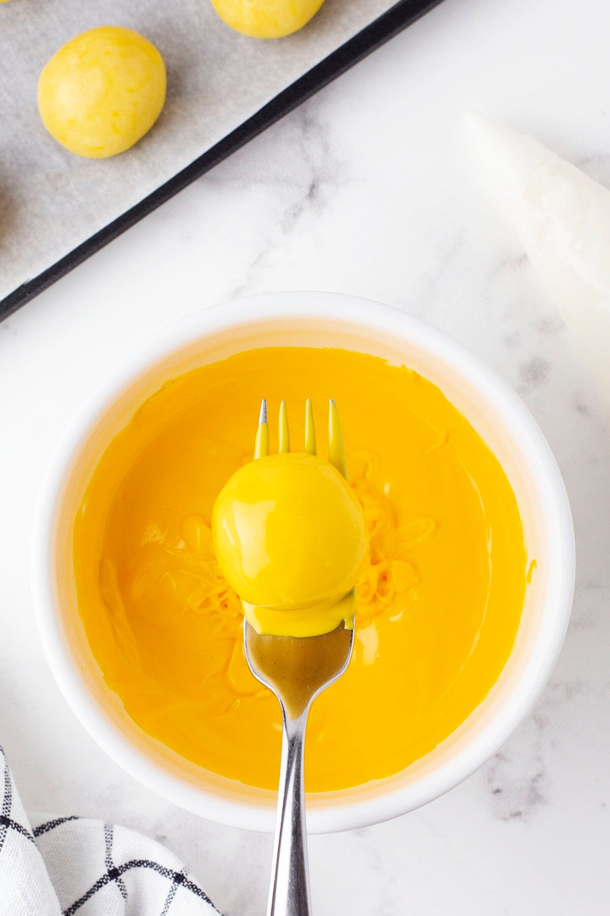 Lemon Cheesecake Bites Coat in Yellow Candy Melts with Fork