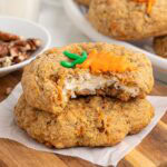 Carrot cake stuffed cookies with a creamy cheesecake filling, topped with a small icing carrot decoration.